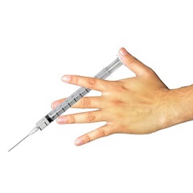 Hand holding a syringe