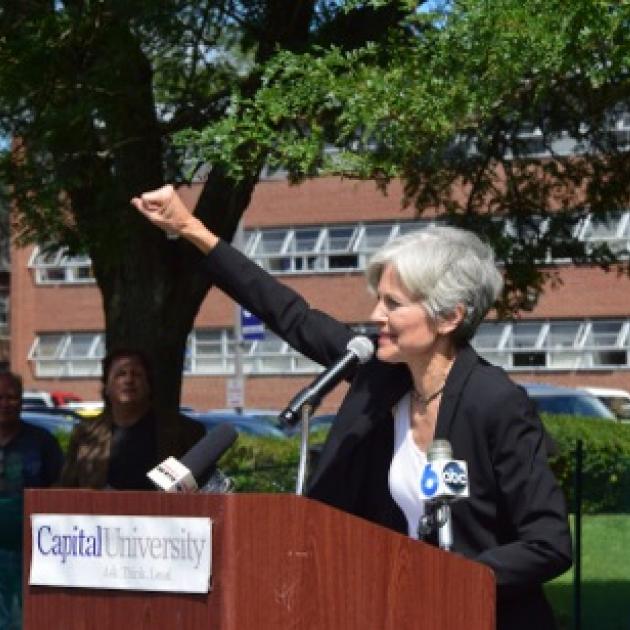 Jill Stein raising her fist at the podium