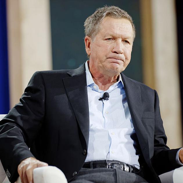 Kasich sitting and making a face