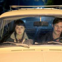 Man and young woman in front seat of car