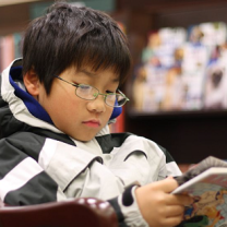 An asian boy reading GRAPHiC N0VEL in a Barnes & Noble bookstore in West Hartford, Connecticut