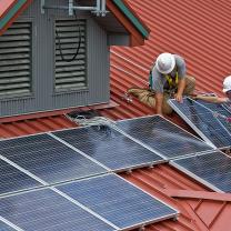 Men installiing solar panels on a roof