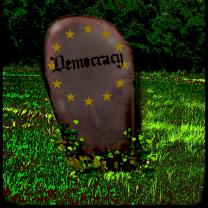 Tombstone that says Democracy on it in a grassy field