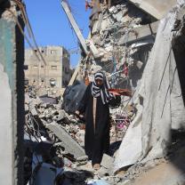 Woman standing amid rubble