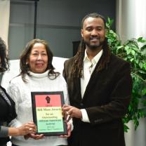 Sherri and Butch posing on each side of Ruth Moss holding award