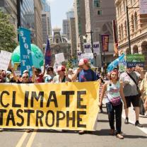 People marching with large banner about climate catastrophe