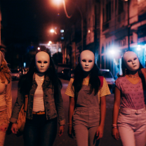 Women walking at night wearing masks