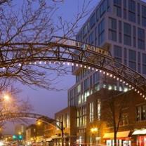 Lighted metal arch over street next to tall building