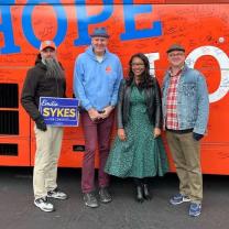 Four people standing and posing