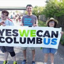 People outside holding a Yes We Can banner